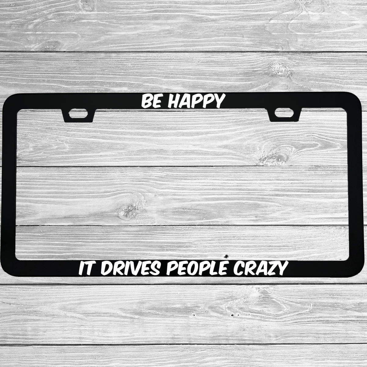 Close-up of "Be Happy It Drives People Crazy" license plate frame showing fade-proof print quality
