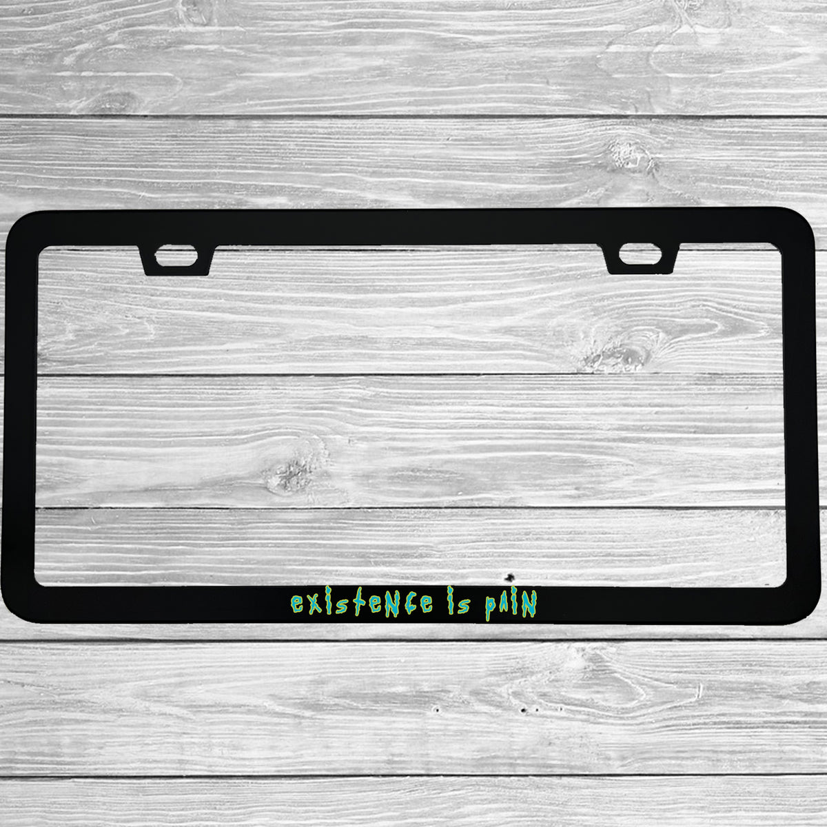 Close-up of "Existence is Pain" license plate frame showing fade-proof print quality