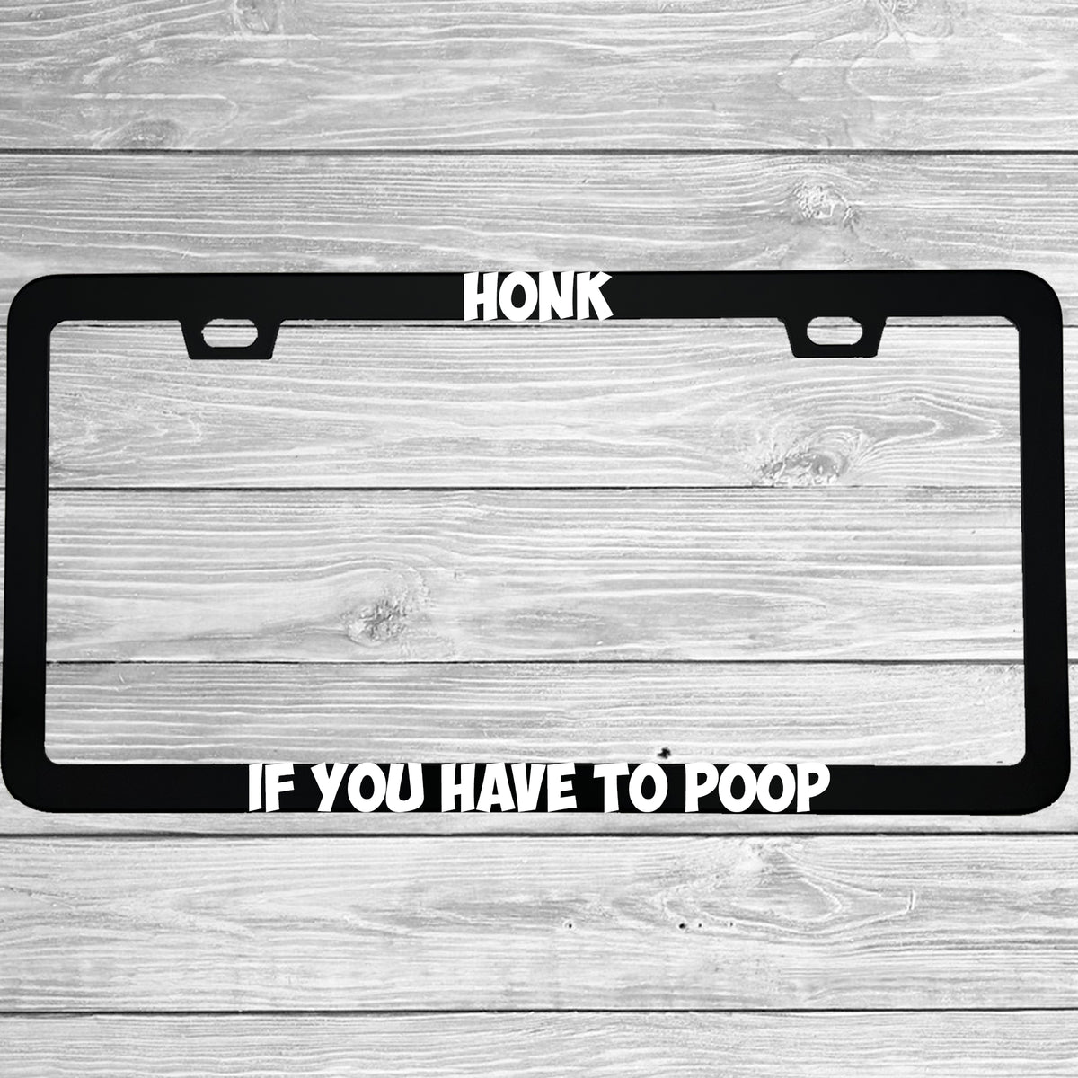 Close-up of "Honk If You Have To Poop" license plate frame showing fade-proof print quality