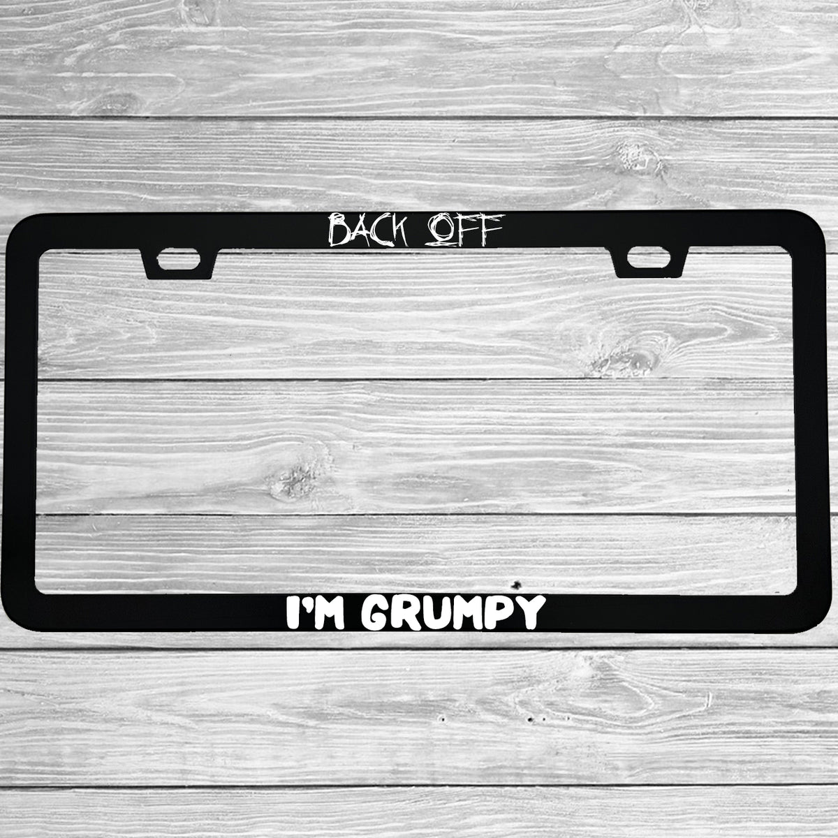 Close-up of "Back Off I'm Grumpy" license plate frame showing fade-proof print quality
