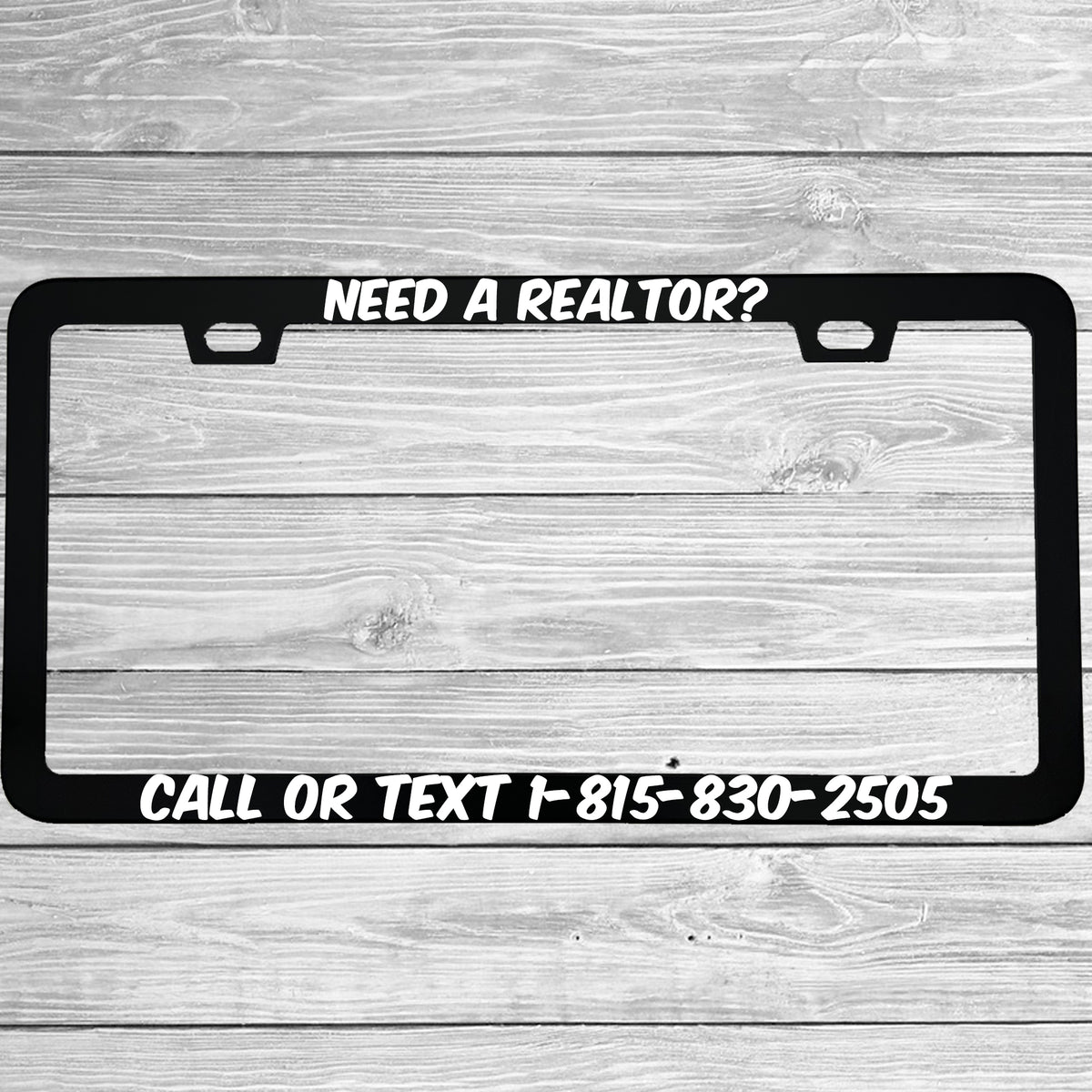 Close-up of "Need A Realtor?" license plate frame showing fade-proof print quality