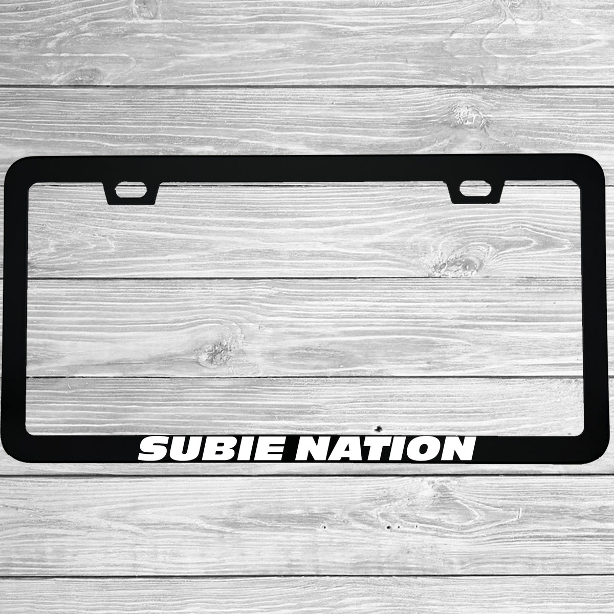 Close-up of "Subie Nation" license plate frame showing fade-proof print quality