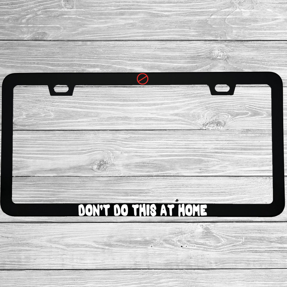 Close-up of "Don't Do This At Home" license plate frame showing fade-proof print quality