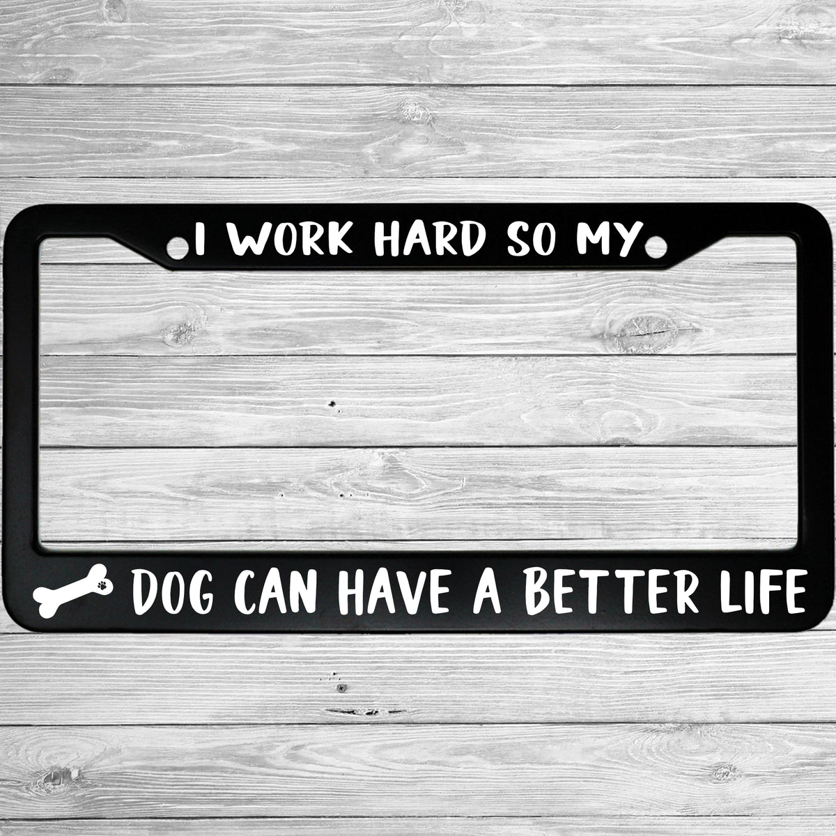 "I Work Hard So My Dog Can Have a Better Life" license plate frame shown on vehicle — lifestyle photo