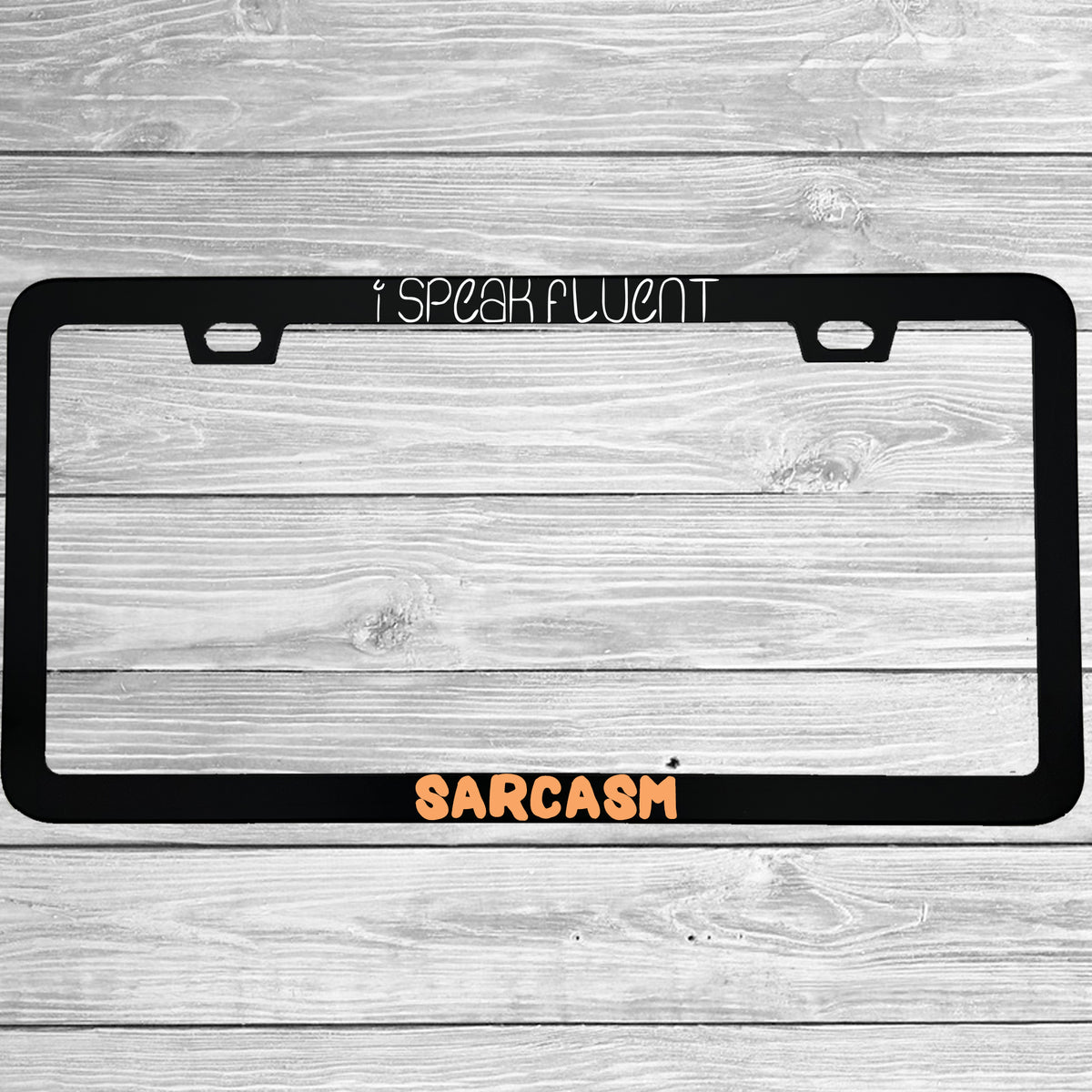 Close-up of "I Speak Fluent Sarcasm" license plate frame showing fade-proof print quality