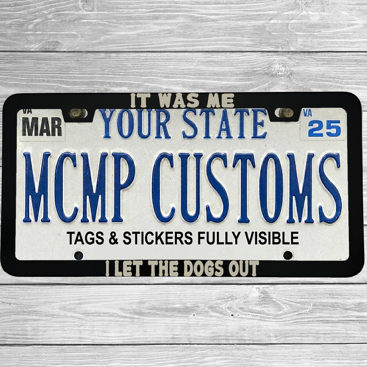 "It Was Me, I Let The Dogs Out" license plate frame shown on vehicle — lifestyle photo