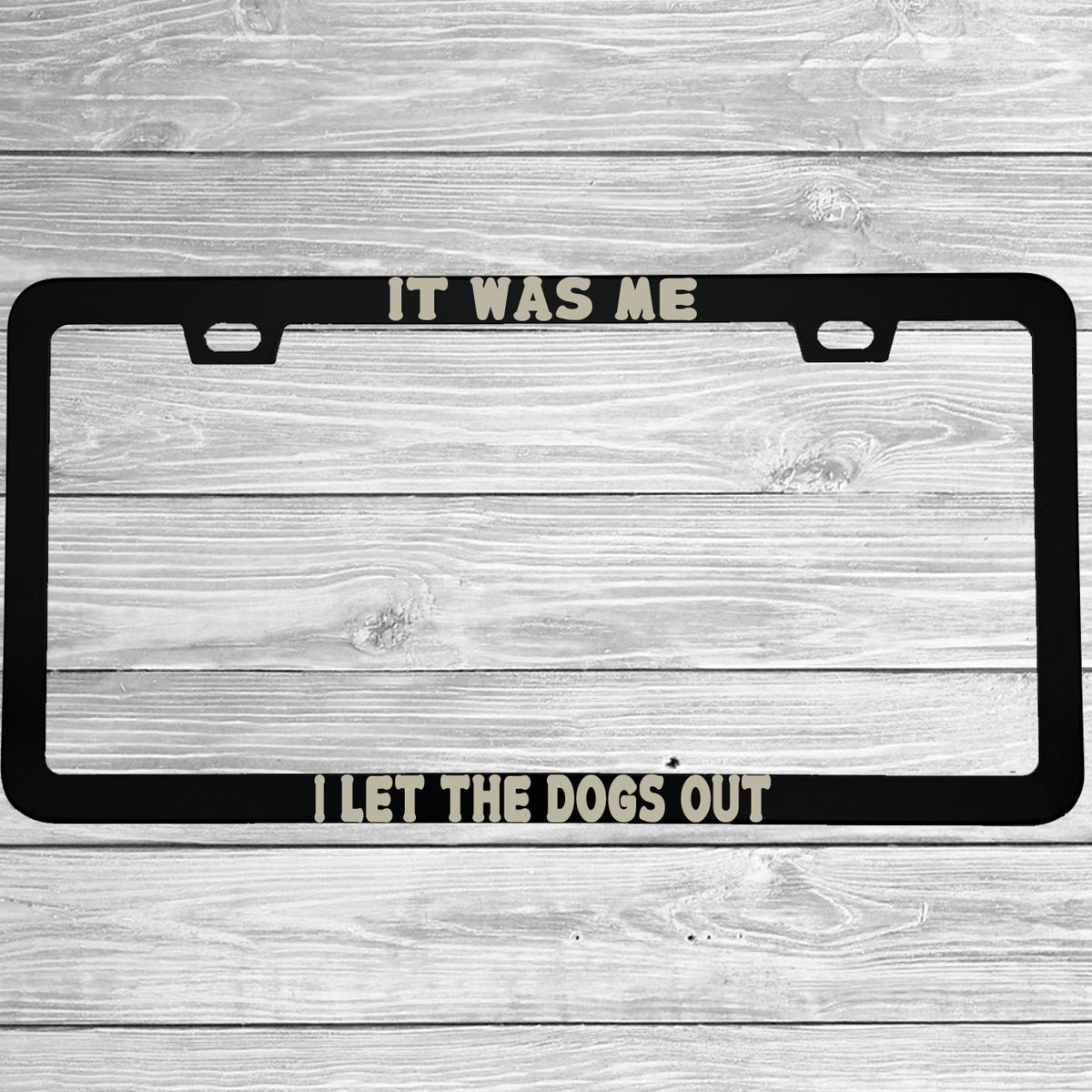 Close-up of "It Was Me, I Let The Dogs Out" license plate frame showing fade-proof print quality