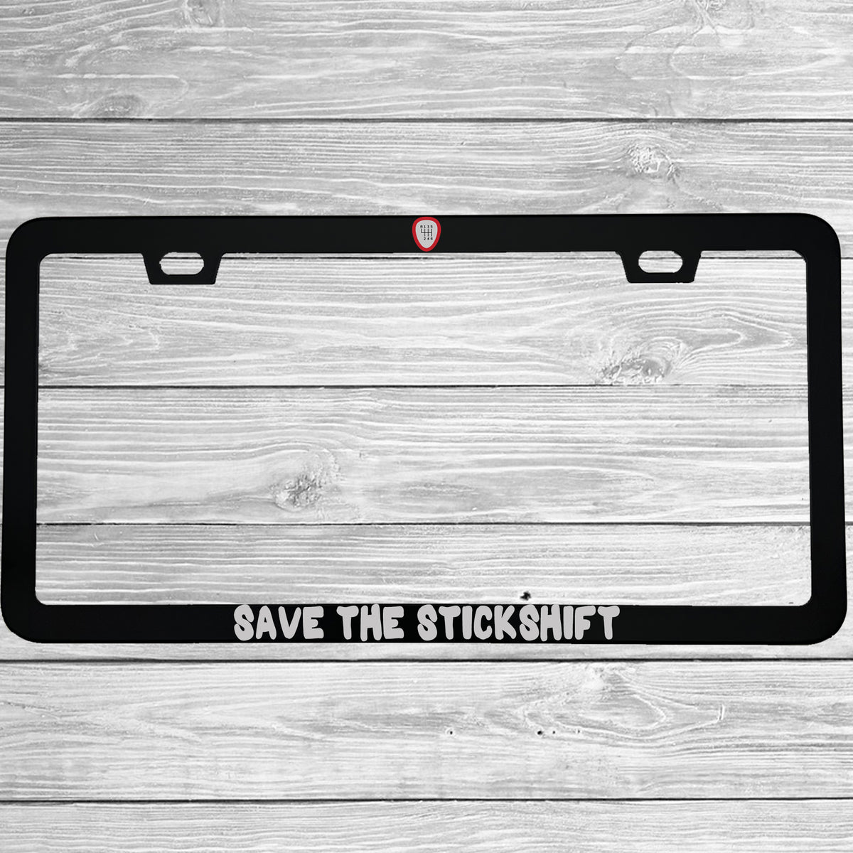 Close-up of "Save The Stickshift Manual Driving" license plate frame showing fade-proof print quality
