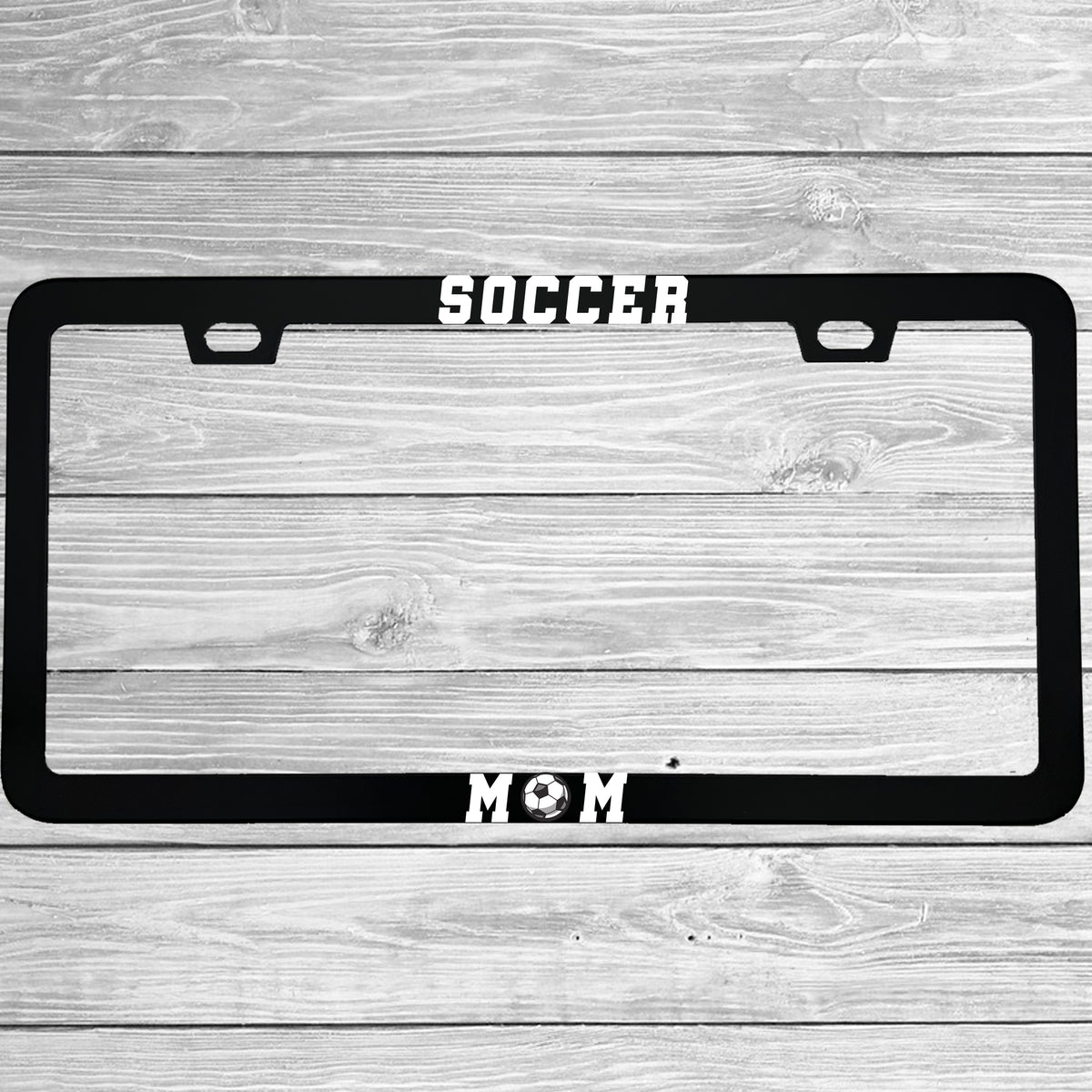 Close-up of "Soccer Mom" license plate frame showing fade-proof print quality
