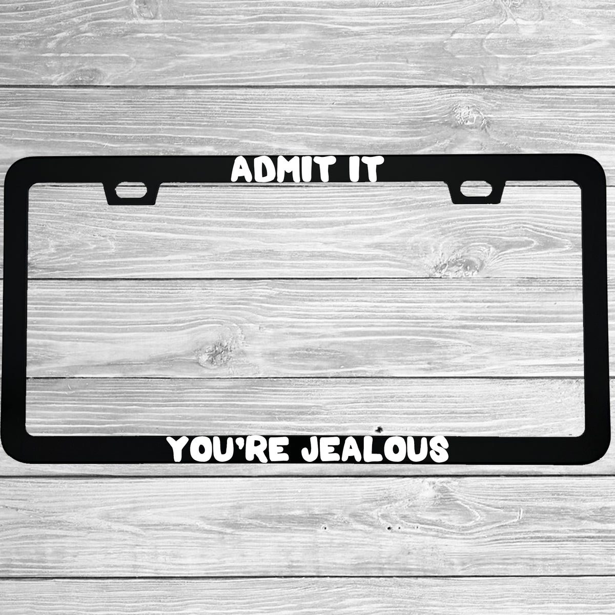 Close-up of "Admit It You're Jealous" license plate frame showing fade-proof print quality