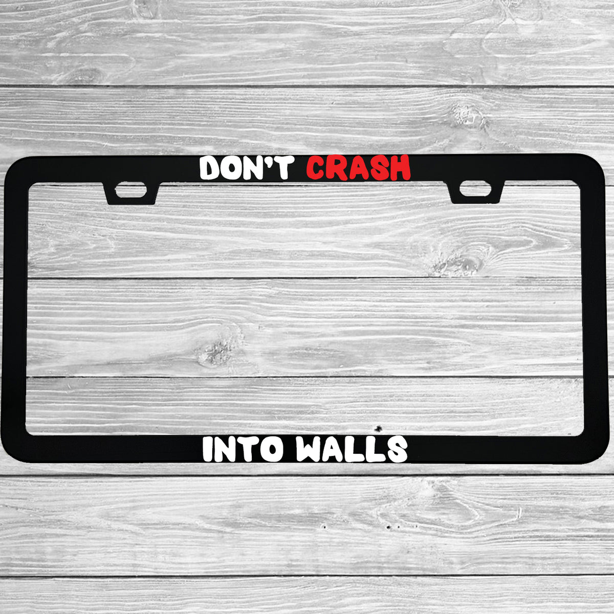 Close-up of "Don't Crash Into Walls" license plate frame showing fade-proof print quality