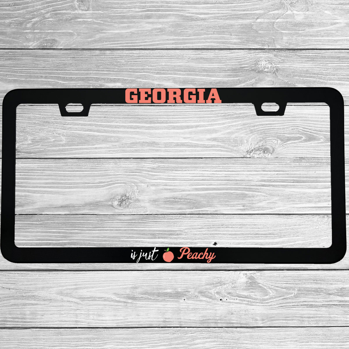 Close-up of "Georgia Is Just Peachy" license plate frame showing fade-proof print quality