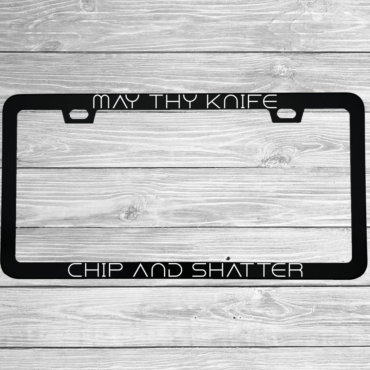 Close-up of "May Thy Knife Chip and Shatter" license plate frame showing fade-proof print quality