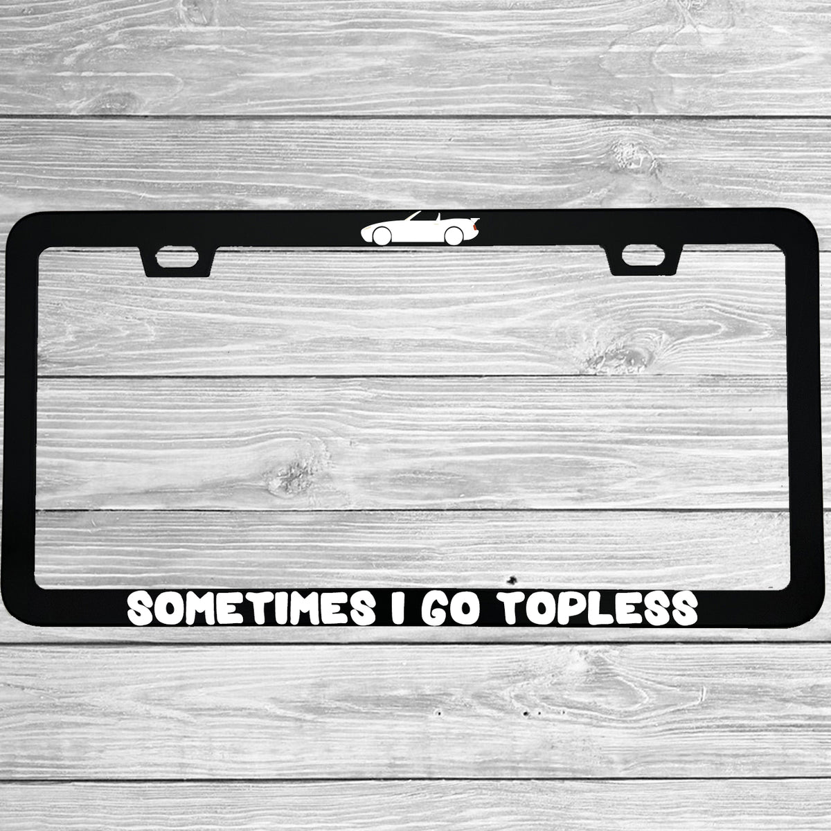Close-up of "Sometimes I Go Topless" license plate frame showing fade-proof print quality